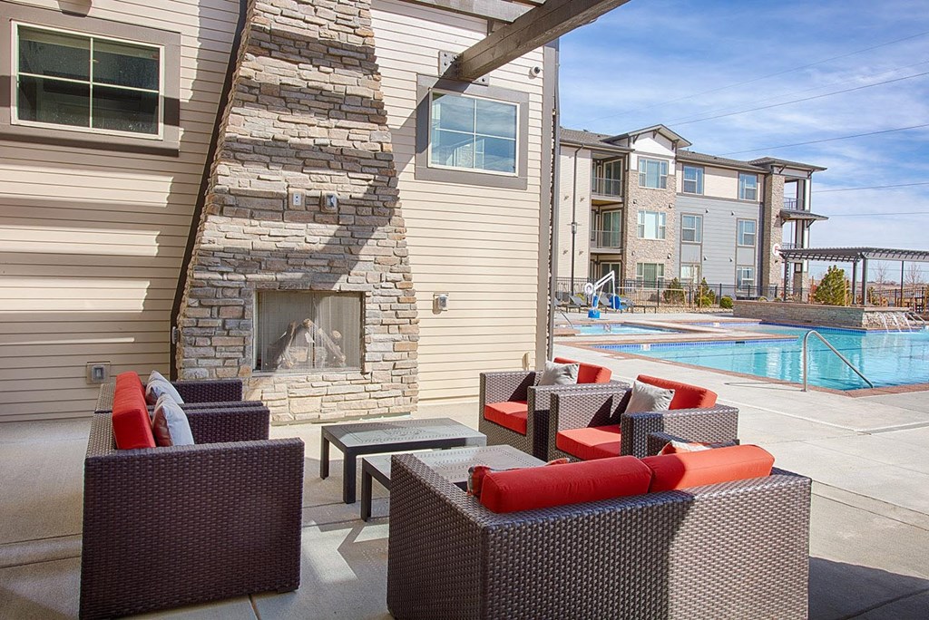 Outdoor Poolside Lounge with Chairs and Fireplace