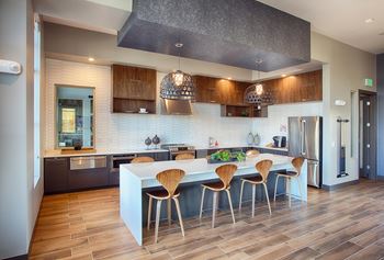 Community Room with large white table, full kitchen and overhead lighting