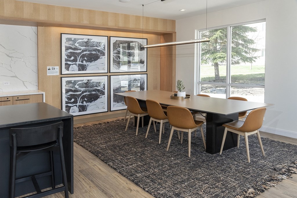 a dining room with a table and chairs in front of a window