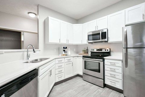a kitchen with stainless steel appliances and white cabinets