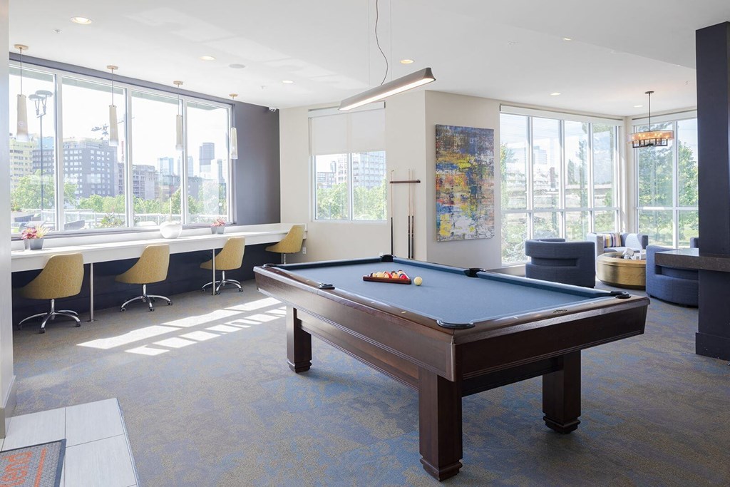 a pool table in a room with large windows