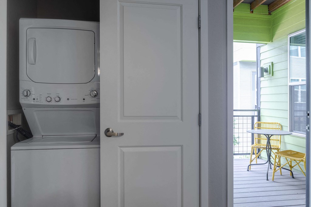 In unit stacked washer dryer in closet near balcony door.