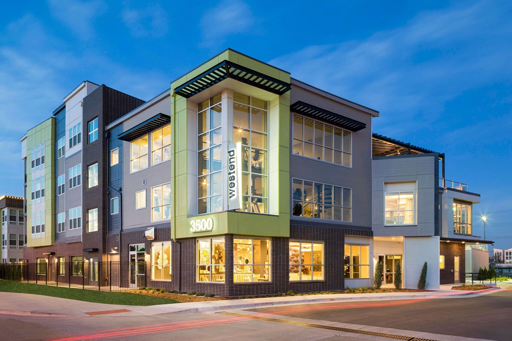 Exterior image of Westend Apartments building lit up at night time.