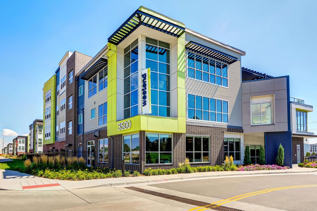 Exterior of Westend Apartments. Building features large windows and lime detailing on the front corner.