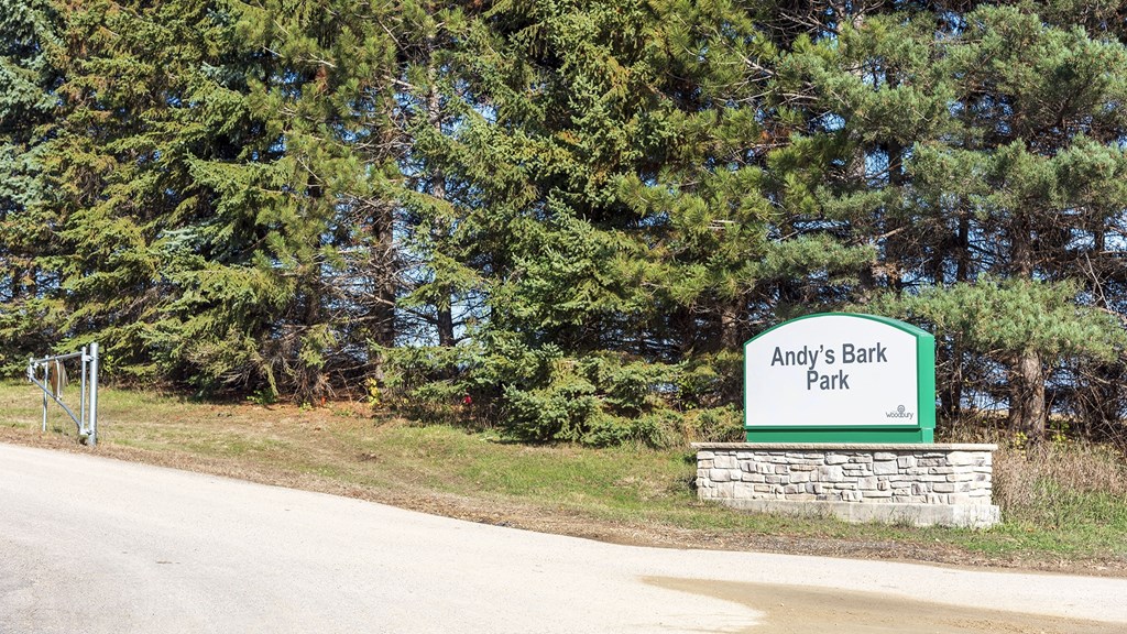 a sign for andys earth park on the side of a road