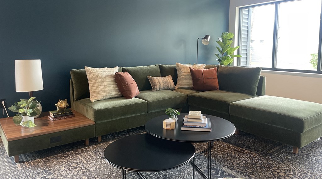 a living room with a green couch and a coffee table