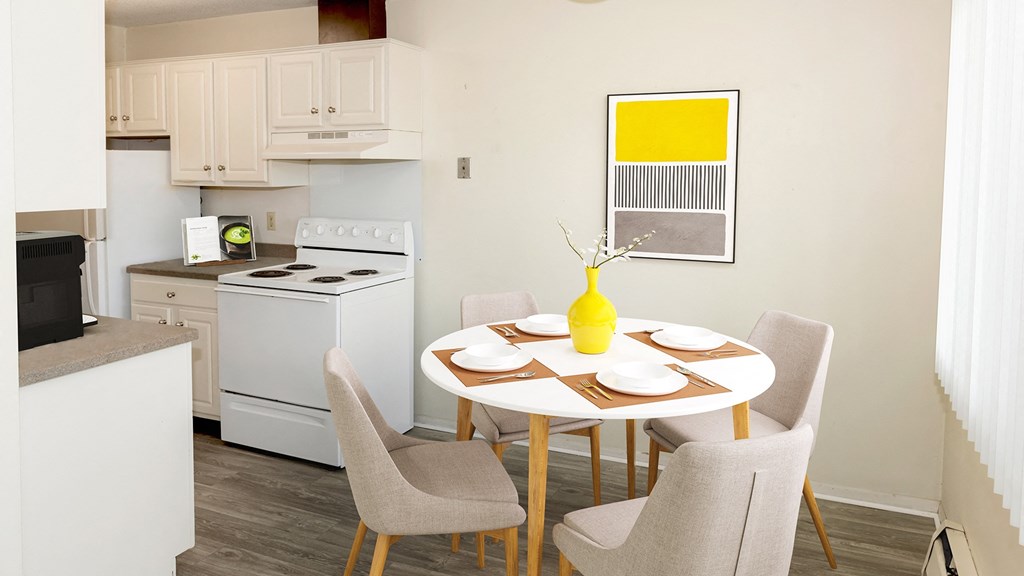 a kitchen with white appliances and a table with chairs