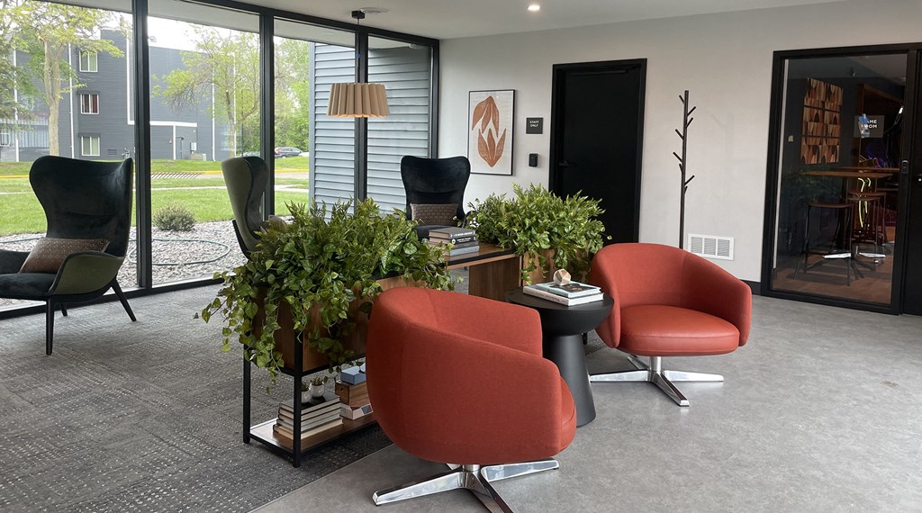 a living room with chairs and a table with plants