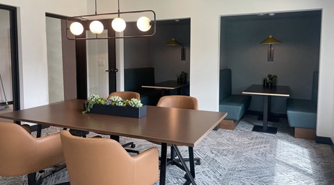a conference room with a table and chairs and a large mirror