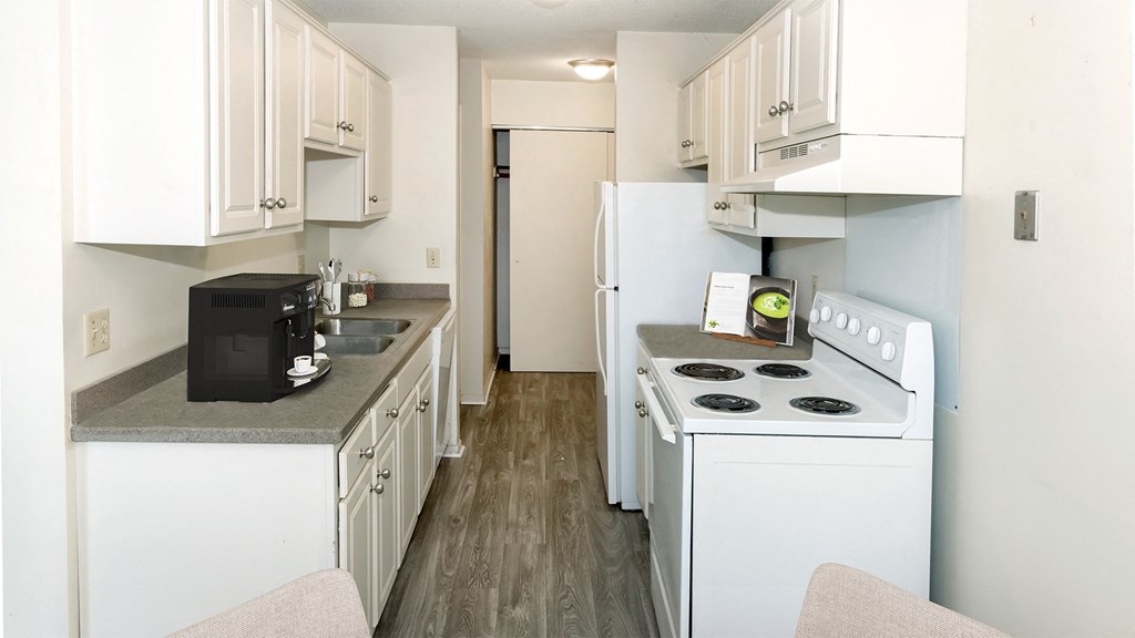 a kitchen with white appliances and white cabinets and a white refrigerator