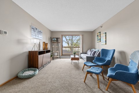 A living room with a blue chair and a grey couch.