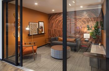 a living room with orange walls and a large mural on the wall