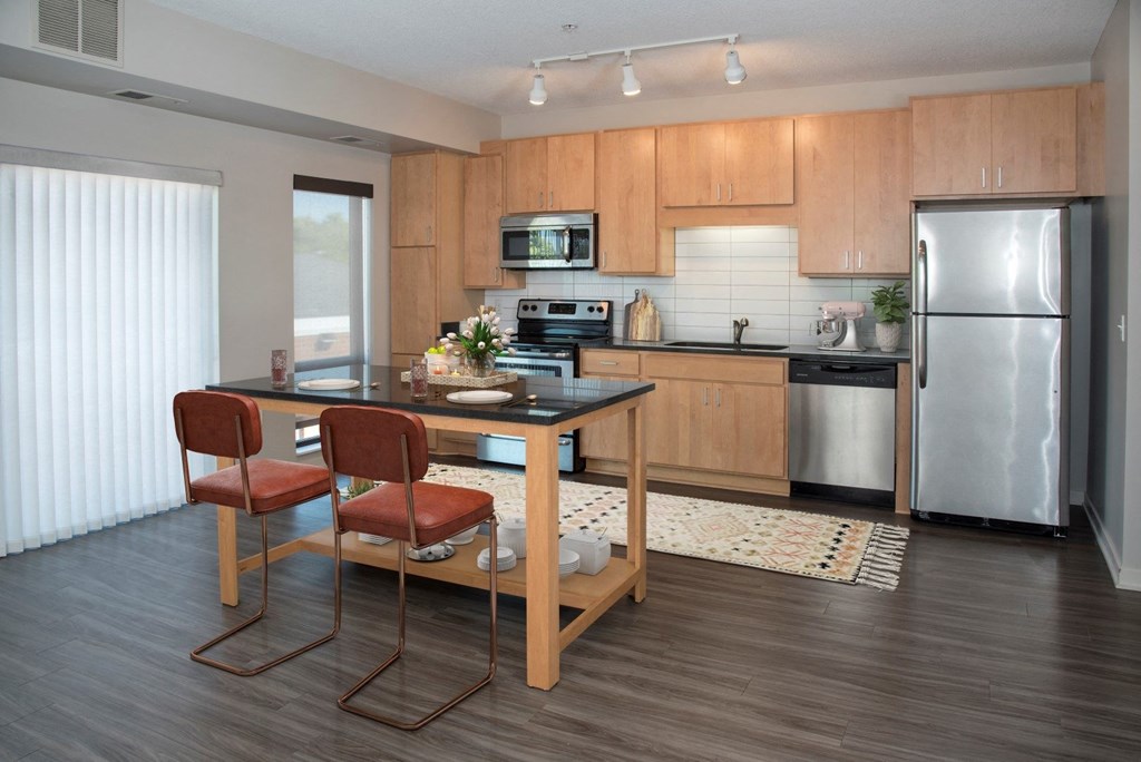 Kitchen with island, stainless steel appliances, granite countertops and large windows