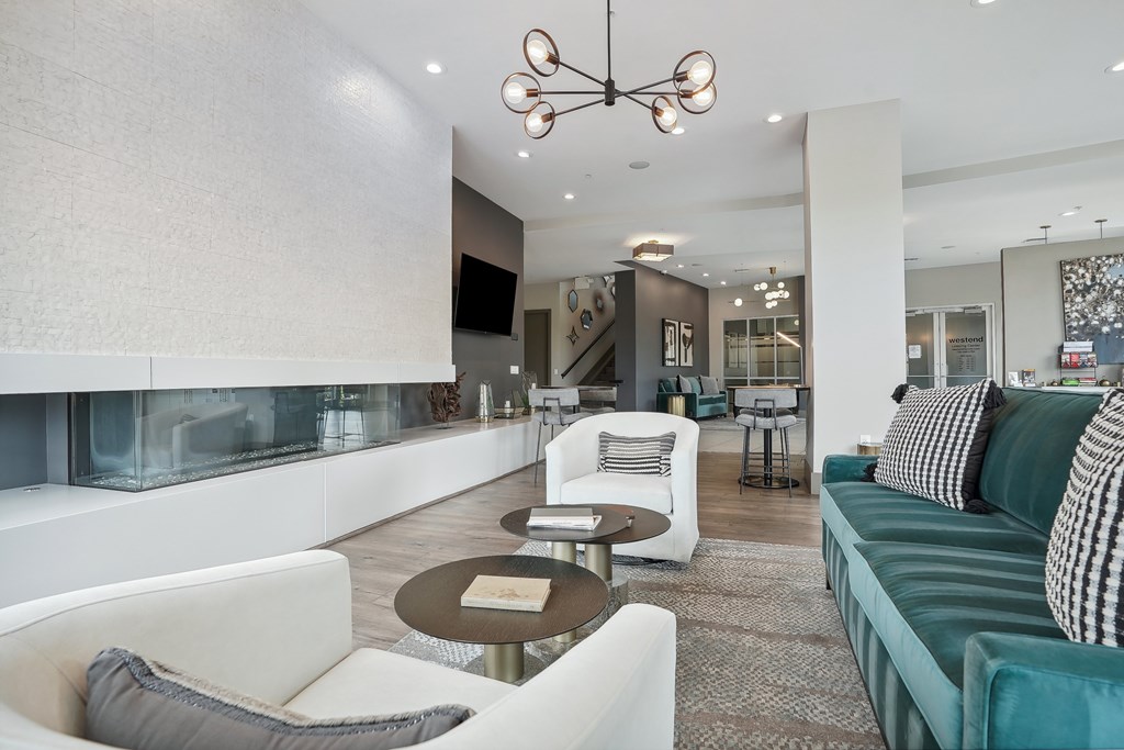 A modern living room with a white sofa and a glass fireplace.
