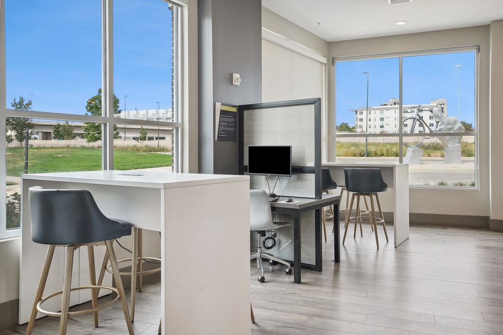 A modern home office with a desk, chairs, and a television.