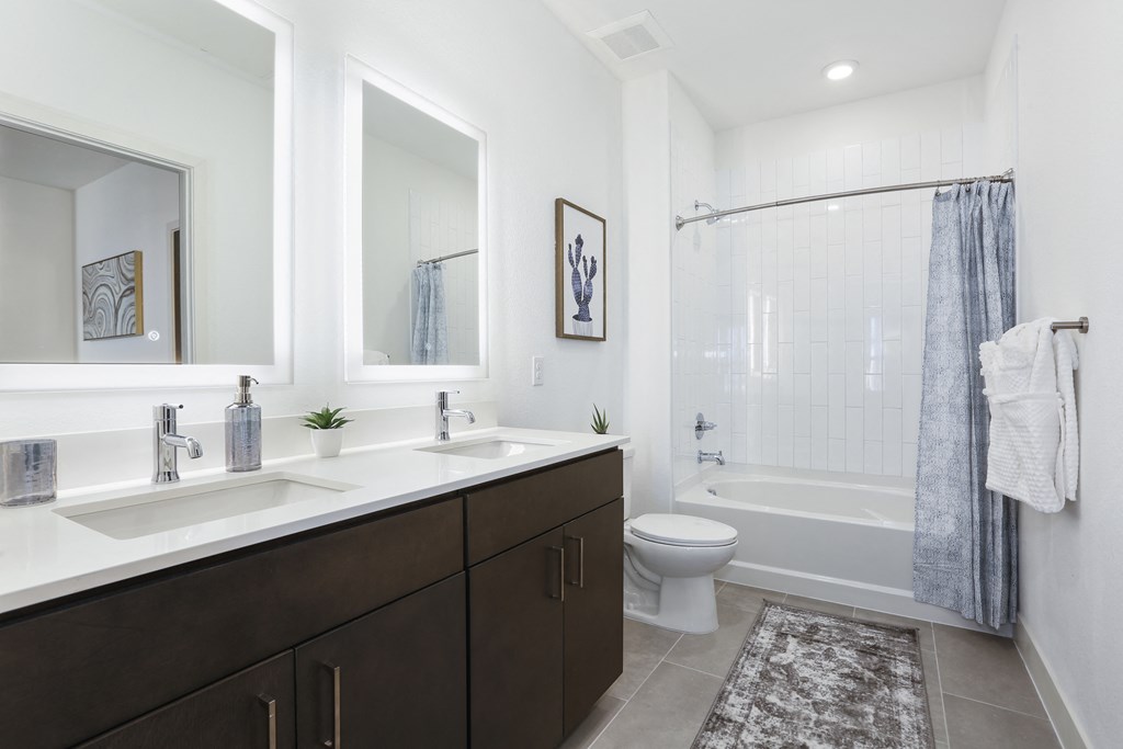 a bathroom with two sinks and a shower and a toilet