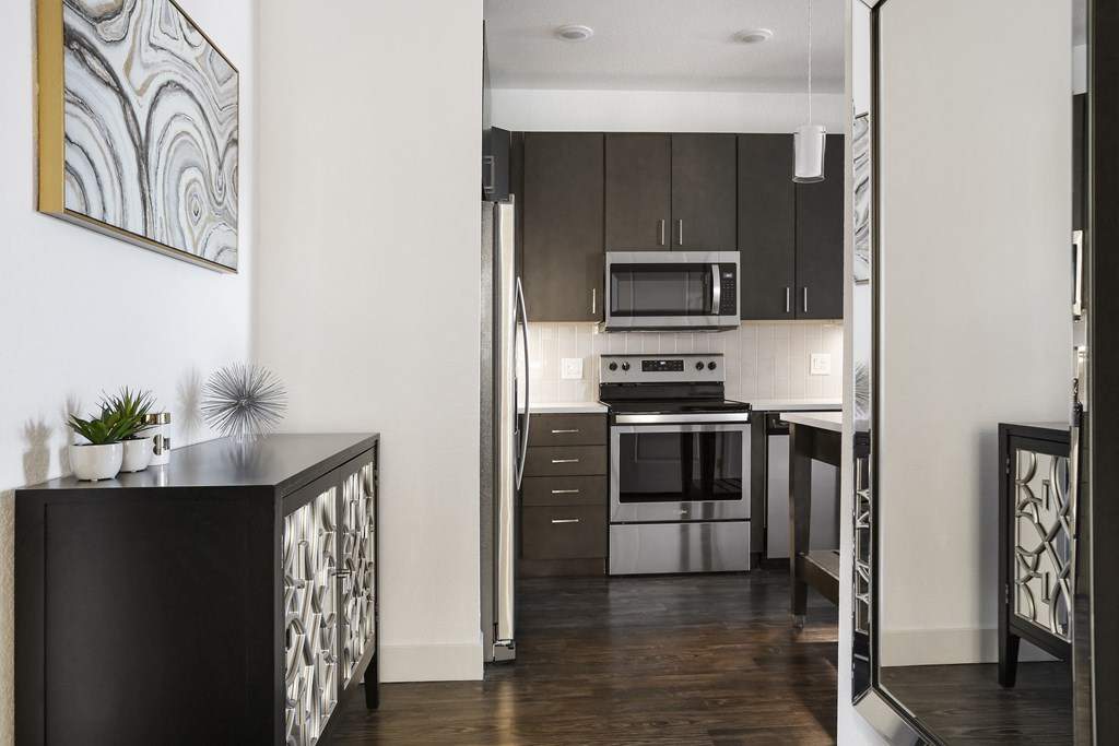 a kitchen with stainless steel appliances and dark wood cabinets