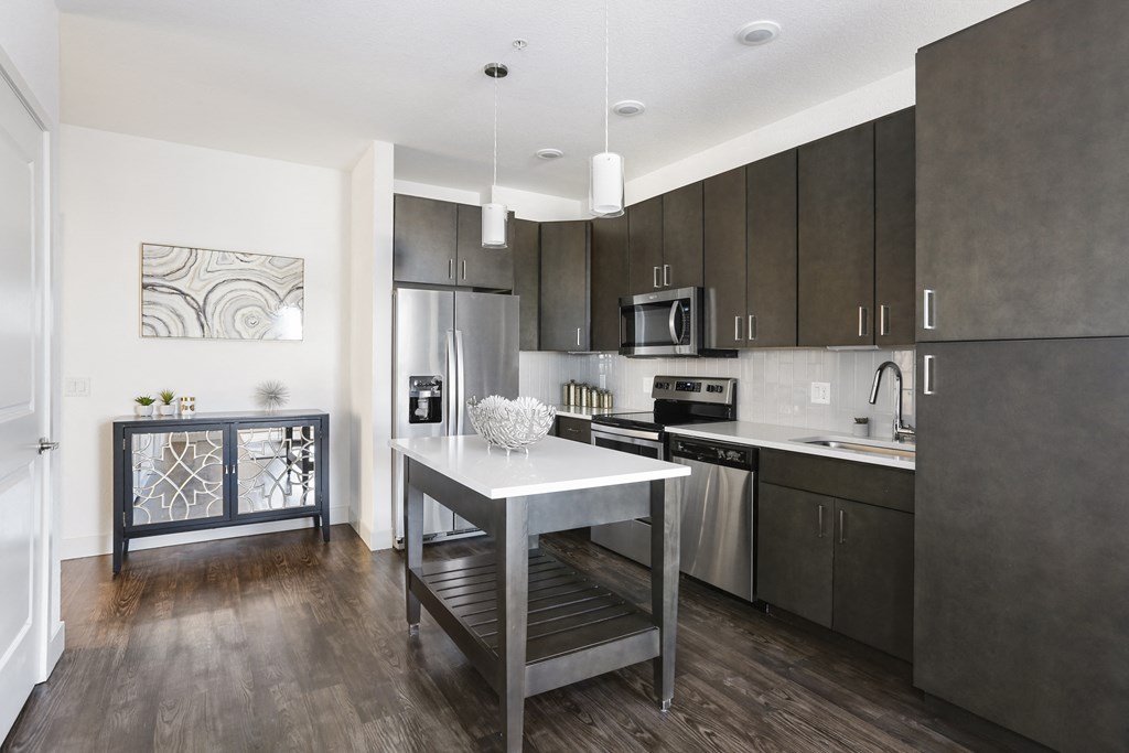 a kitchen with stainless steel appliances and a white island in the middle
