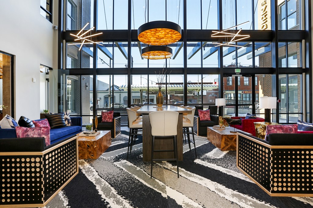 a lounge area with couches chairs and a table in a building with large windows