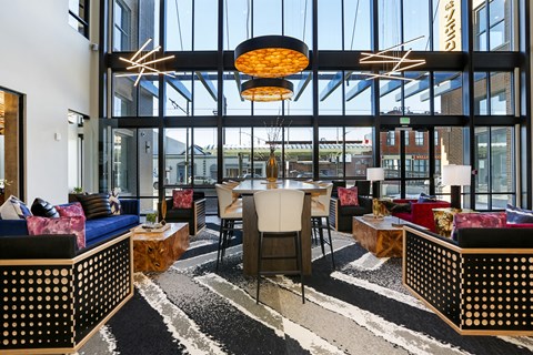 a lounge area with couches chairs and a table in a building with large windows