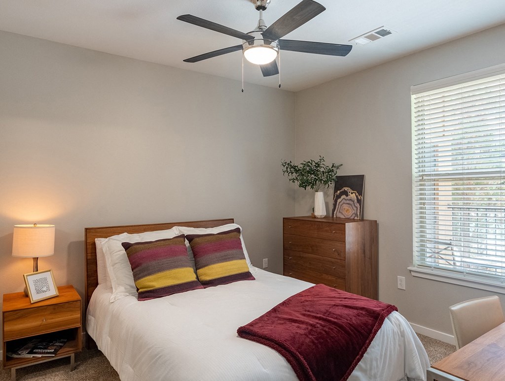 a bedroom with a ceiling fan and a window