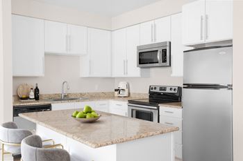 a kitchen with white cabinets and stainless steel appliances