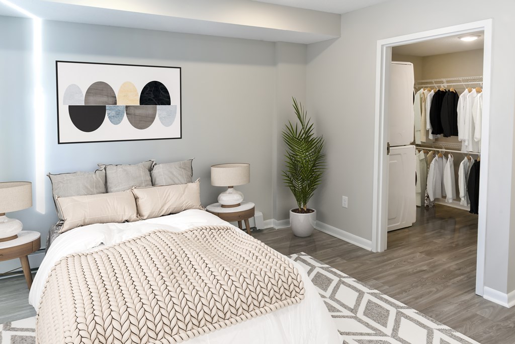 A bedroom with a large bed and a painting on the wall.