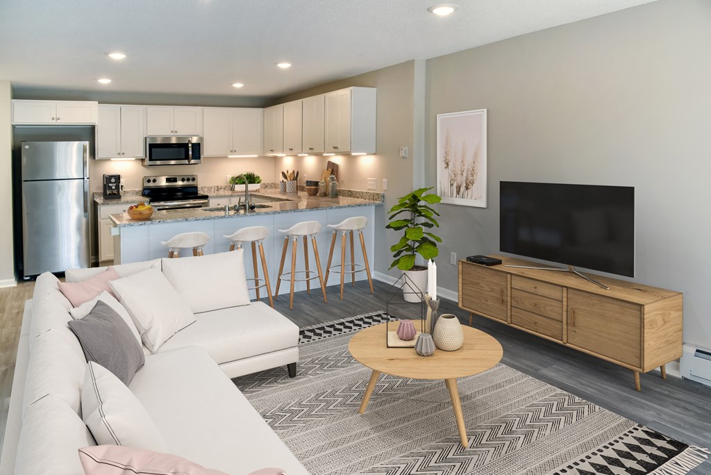 A modern living room with a white sofa, wooden coffee table, and a television.