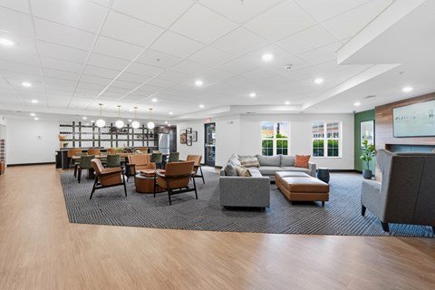 A spacious waiting room with wooden floors and a variety of seating options.