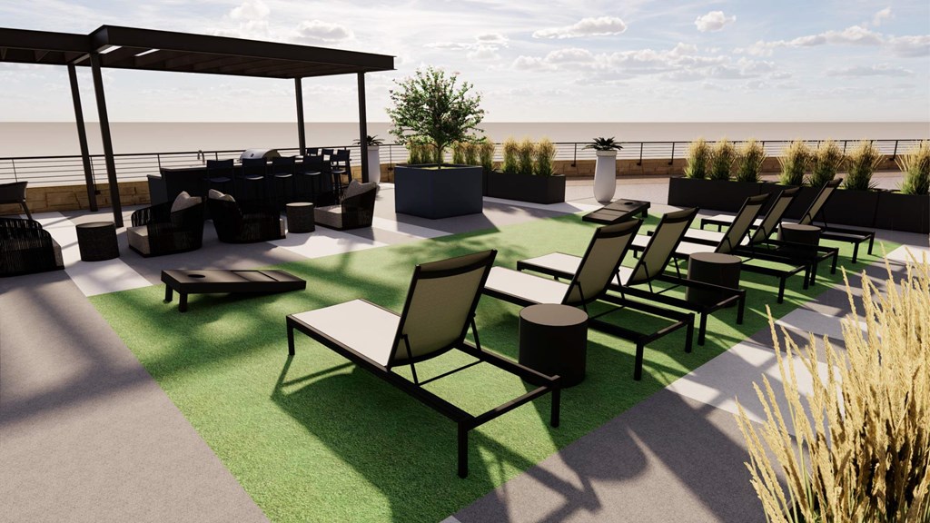 A patio with black furniture and a green lawn.