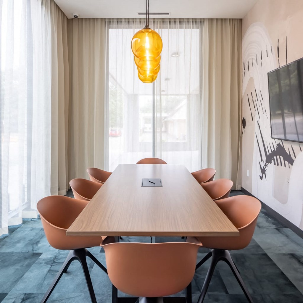 a meeting room with a long wooden table and orange chairs