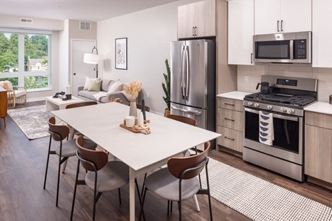 an open kitchen and dining room with stainless steel appliances and a table