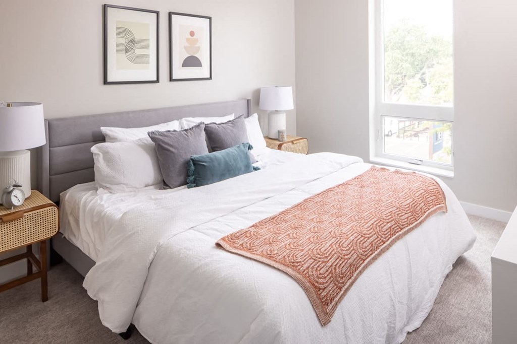 a bedroom with a large bed and two windows