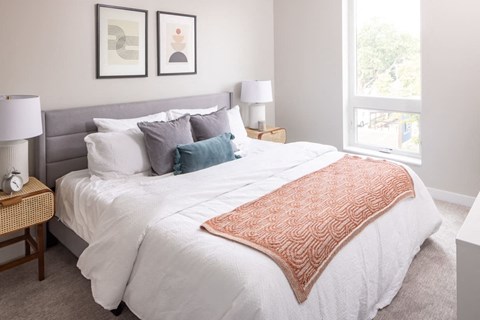 a bedroom with a large bed and two windows