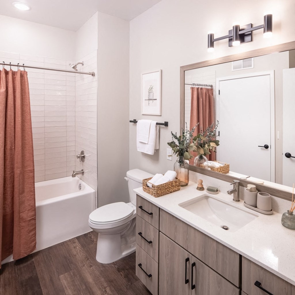 a bathroom with a white toilet next to a white bathtub and a white sink with a