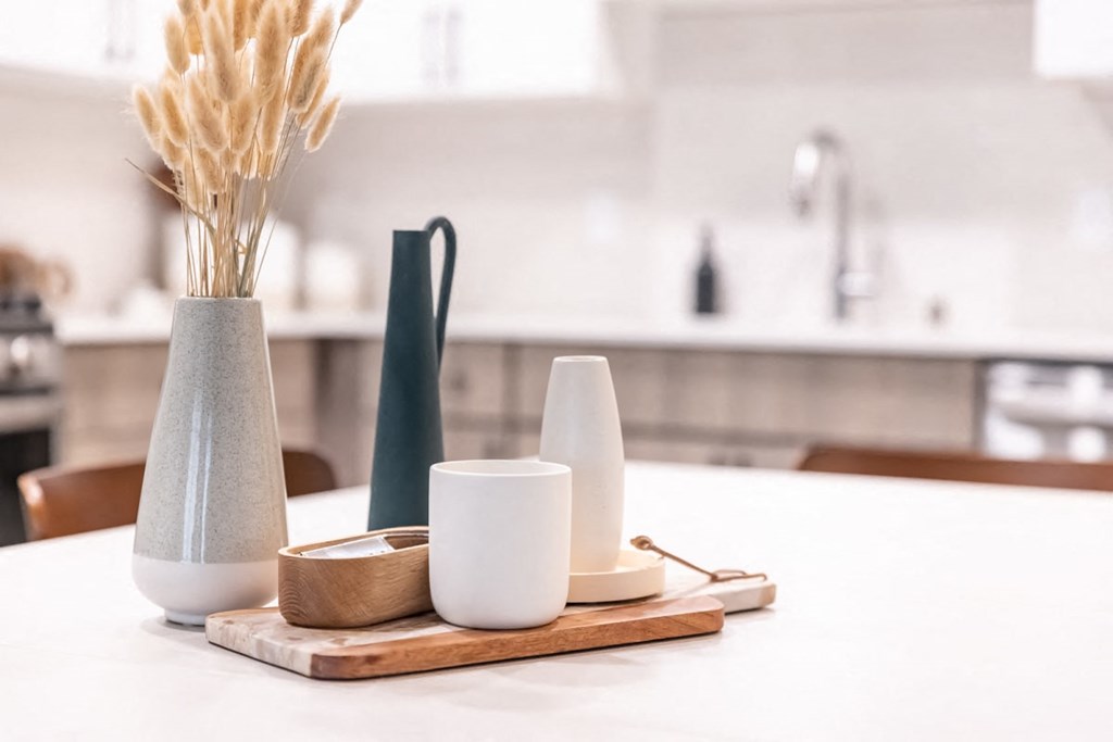 a kitchen table with a vase of wheat on it