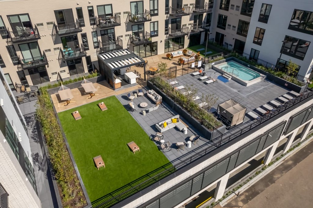 an aerial view of an apartment complex with a lawn and a pool