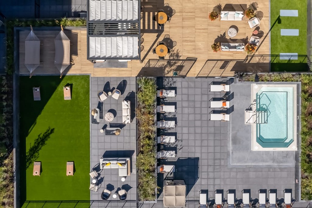 a birdseye view of a backyard with a pool and lawn