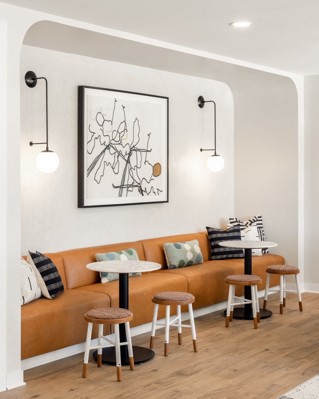 a living room with an orange couch and stools