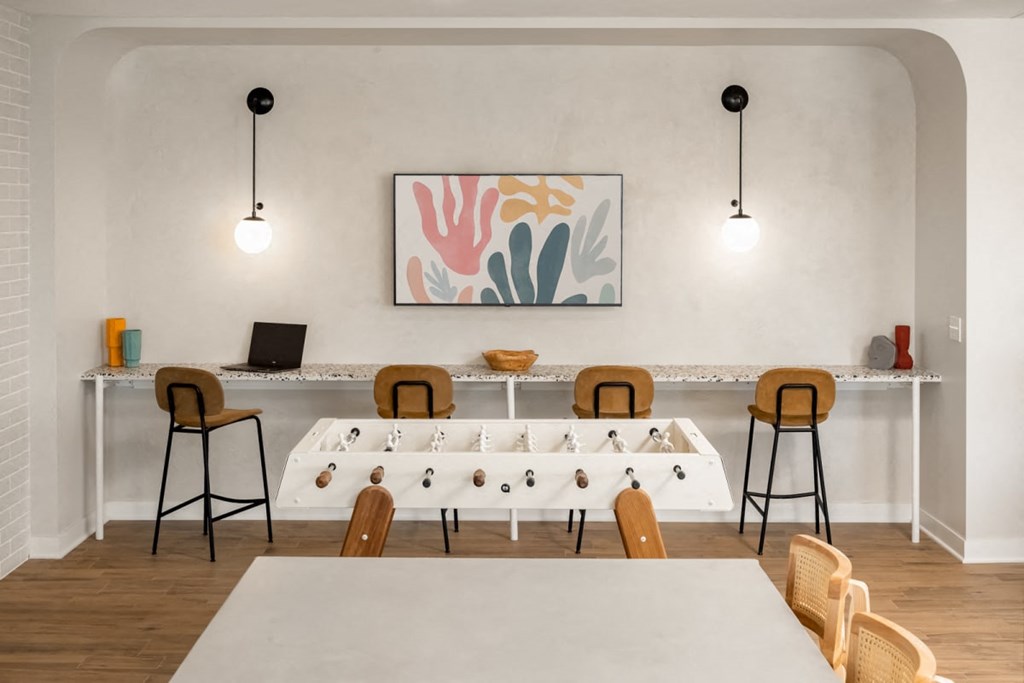 a meeting room with a long table with chairs around it and two lamps hanging from the ceiling