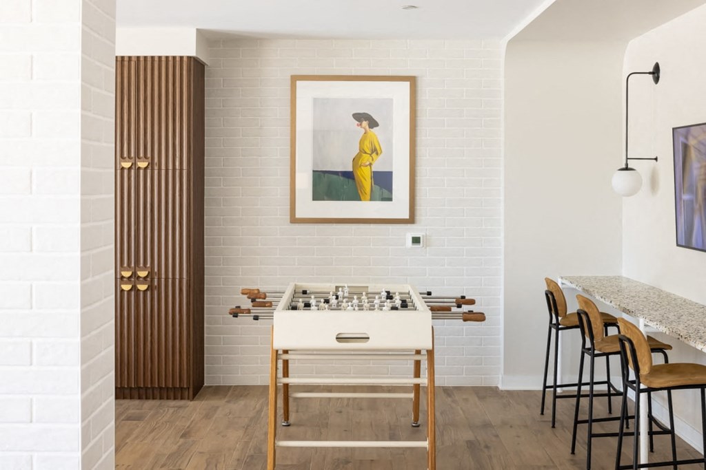 a room with a foosball table and a painting on the wall