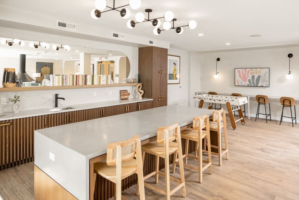 a kitchen with a long counter top and a dining room in the background