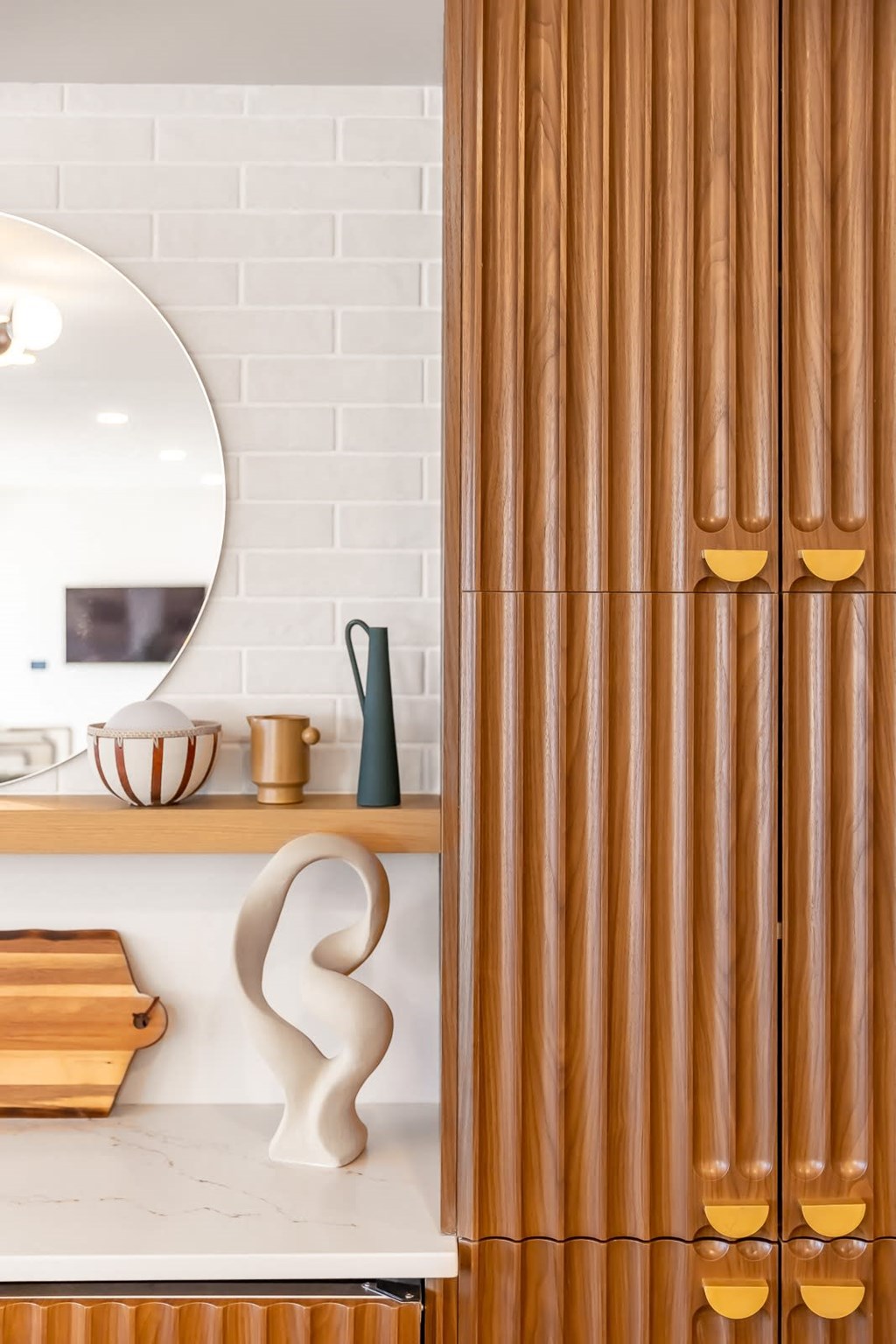 a bathroom with a wooden door and a white countertop with a white sink and a round
