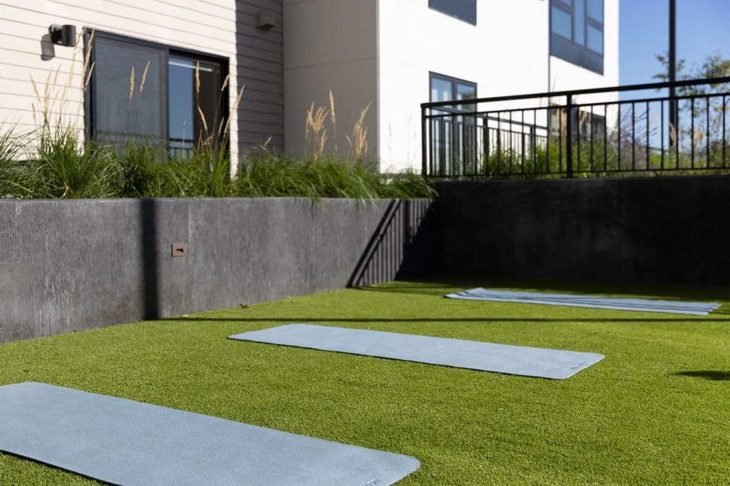 a home gym with synthetic grass and concrete walls