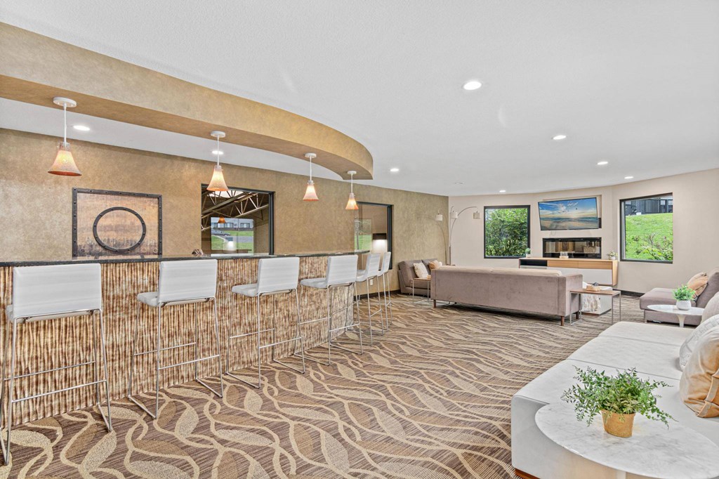 A room with a patterned carpet and a white table with a plant on it.