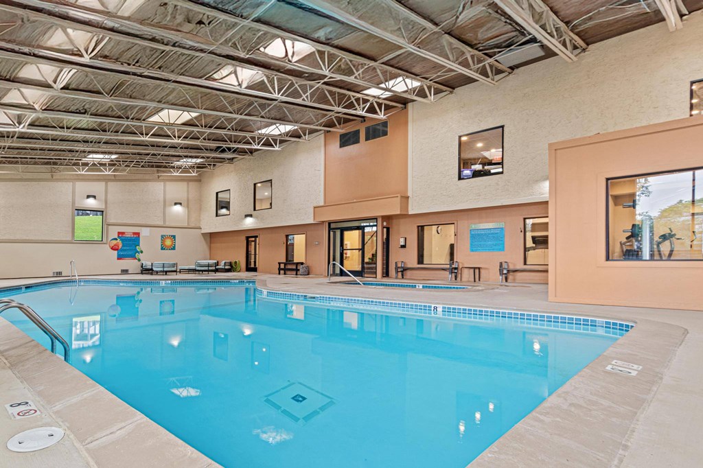A large indoor swimming pool with a blue tiled bottom.