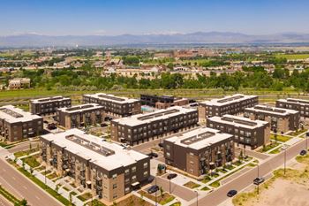 A large apartment complex with a parking lot in front.