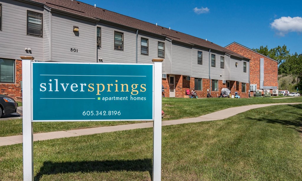 a sign for silver springs apartments in front of a building