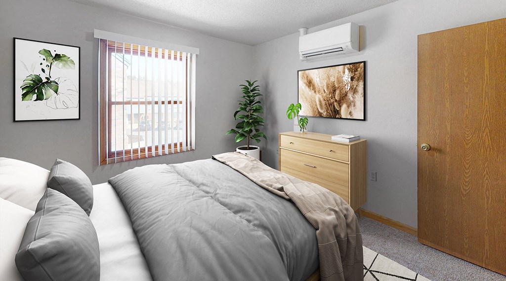 A bedroom with a bed, pillows, a nightstand, and a plant.