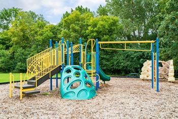 outdoor childerns playground with climbing wall and monkey bars